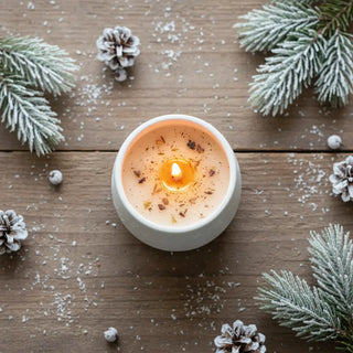 Handgjort vinterdoftljus med snö och tallkvistar